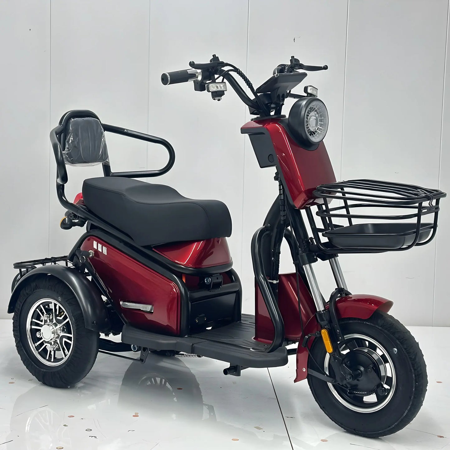 Vedere din față dreapta pentru tricicleta electrică roșie de agrement în exterior.