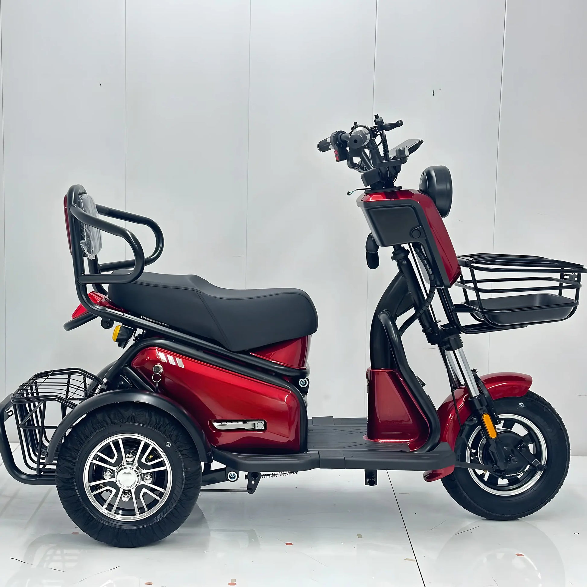 Profil lateral tricicletă electrică roșie, arătând șaua dublă și cele 2 spații de depozitare